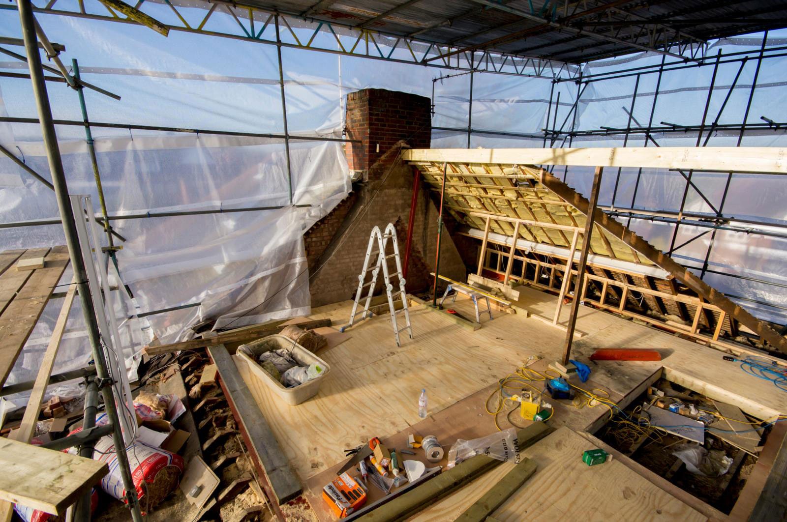 Large scale loft conversion in Bristol with scaffolding supporting the framework of a new roof.